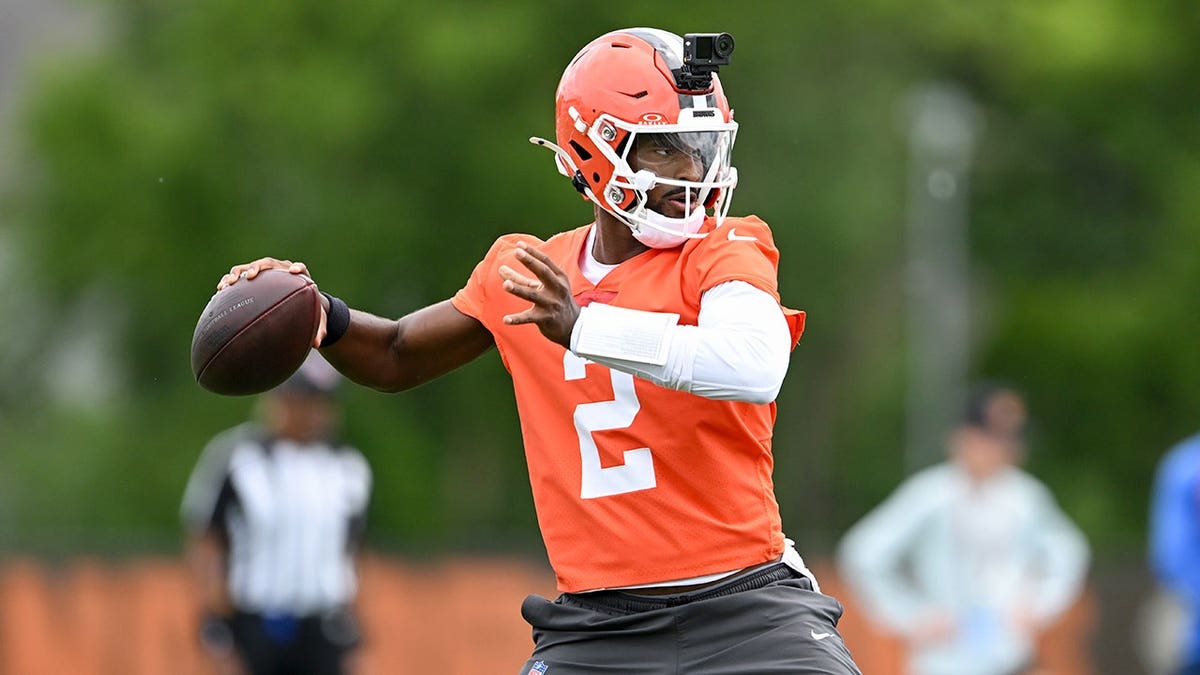 Shedeur Sanders throws a pass during minicamp on a football field.