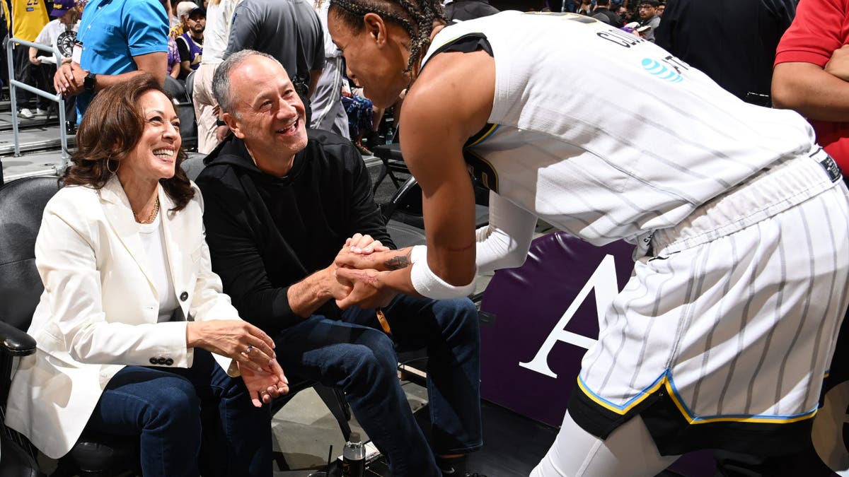 Natasha Cloud le da la mano a Kamala Harris y Doug Emhoff durante un partido de baloncesto en Los Ángeles.