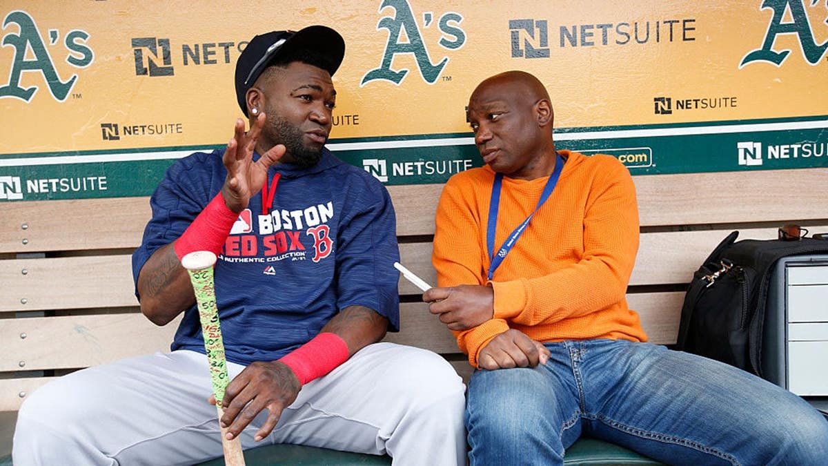 David Ortiz talks with Howard Bryant in the dugout at the Oakland Coliseum.