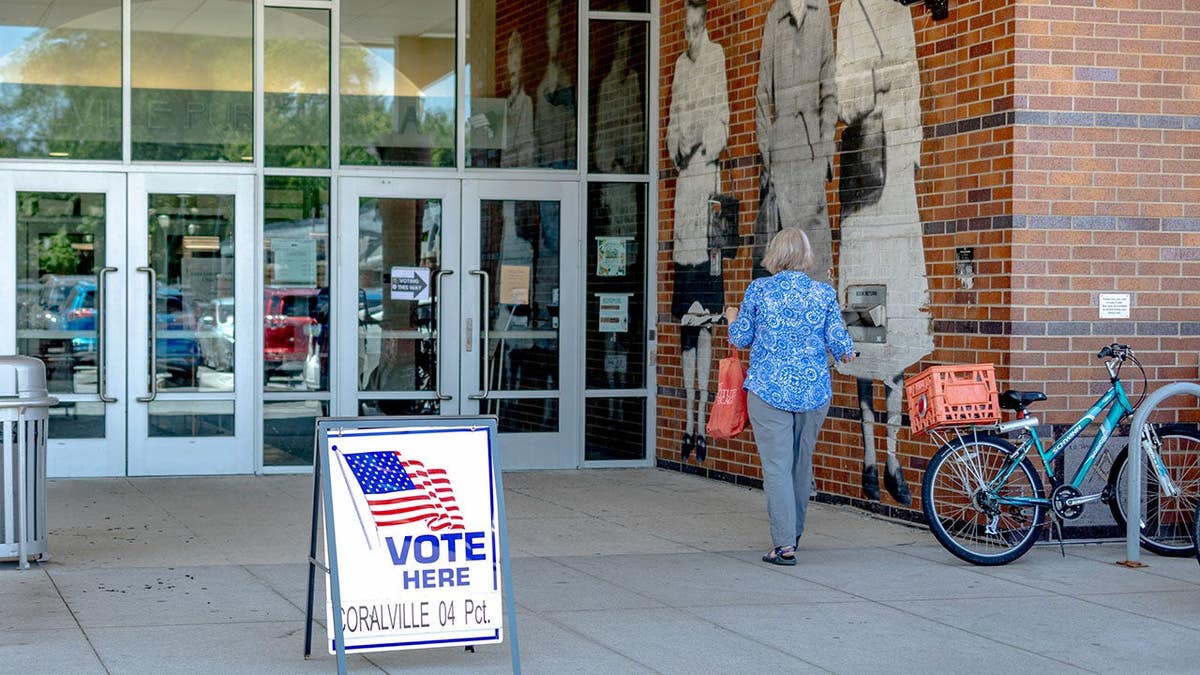Voter casts a ballot at a polling location inside the Coralville Public Library.