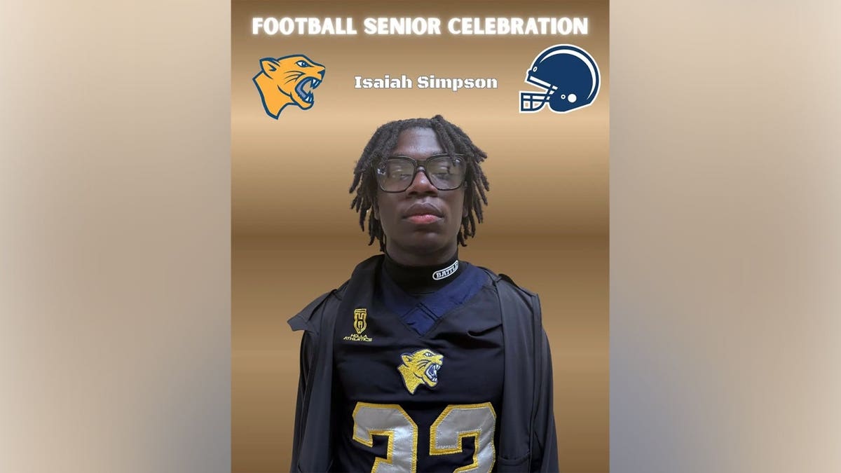 Isaiah Simpson wearing glasses and a black and gold Cheltenham football jersey, pictured in a