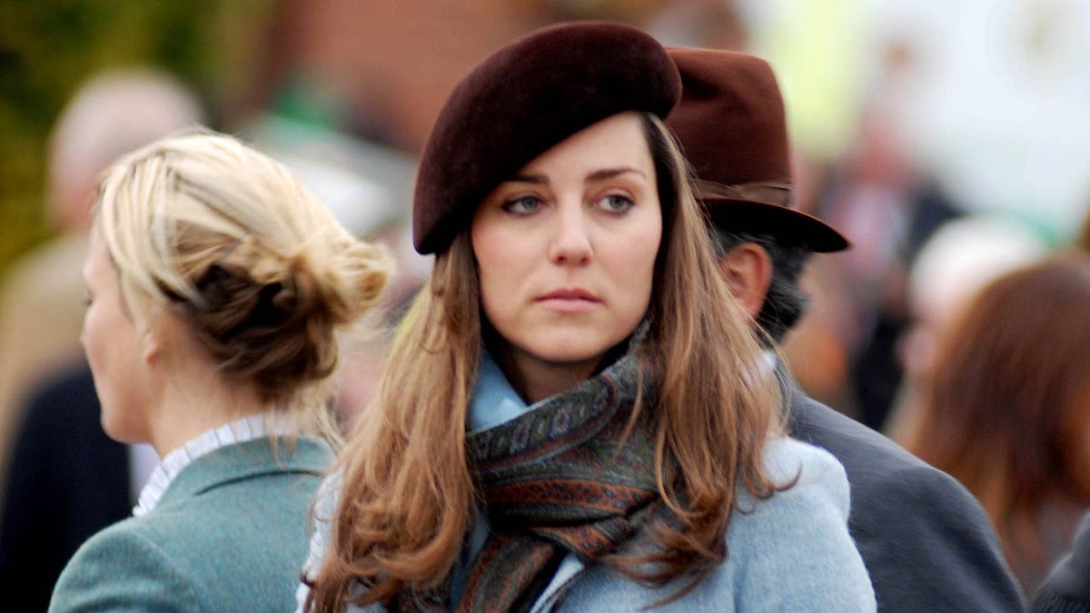 Kate Middleton looking somber wearing a blue coat and a dark beret.