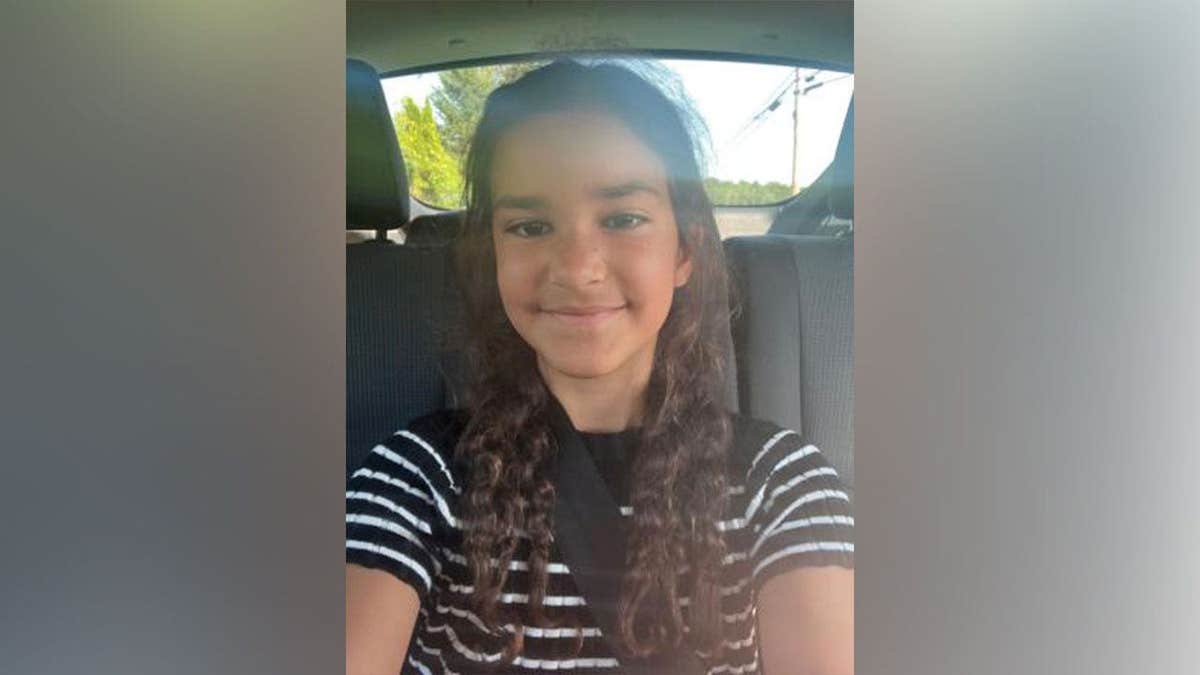 Nine-year-old Melina Frattolin smiles while sitting in the back seat of a vehicle