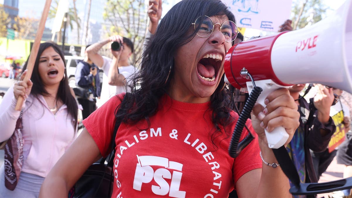 a protestor yells into a megaphone