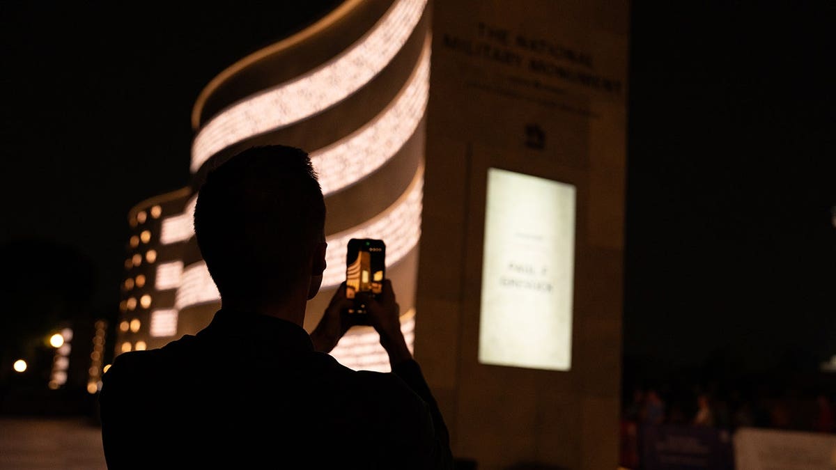 A visitor photographs the National Military Monument in Washington, D.C.