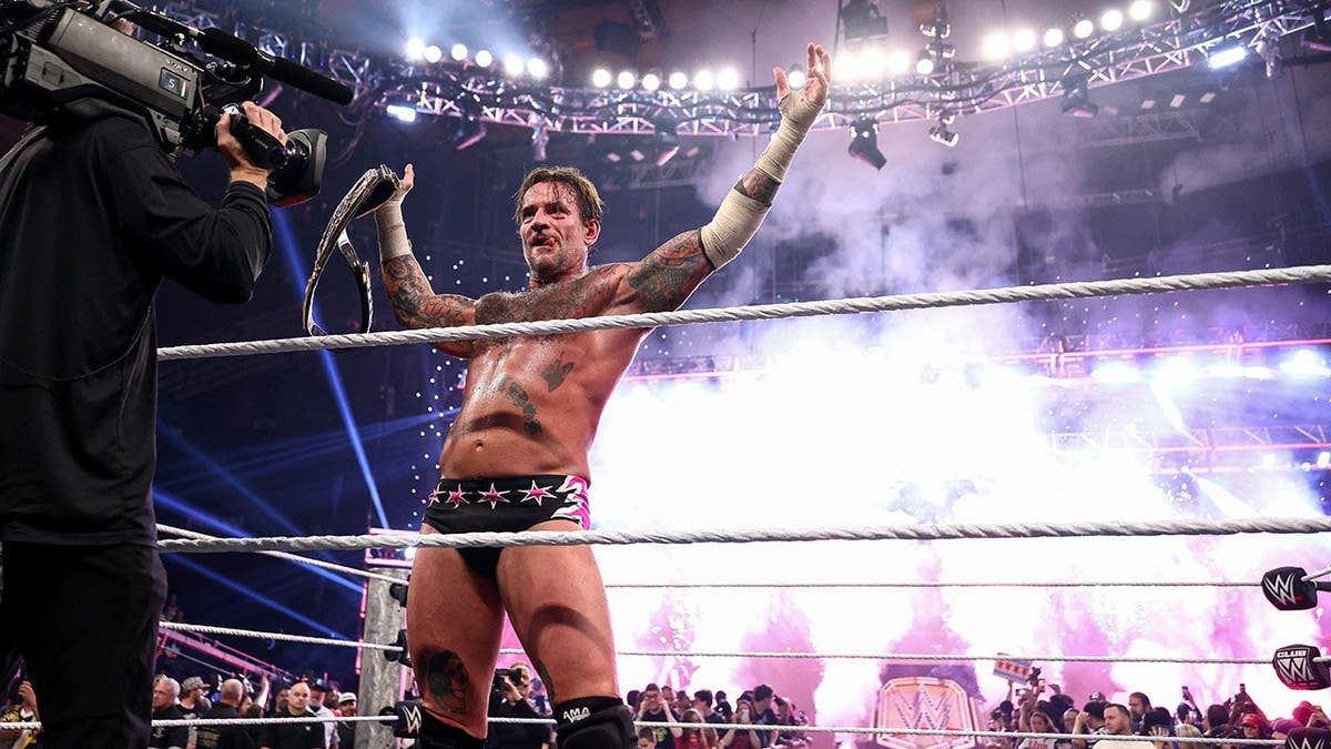CM Punk oslavuje zisk titulu Undisputed WWE Championship v Allstate Arena v Chicagu.