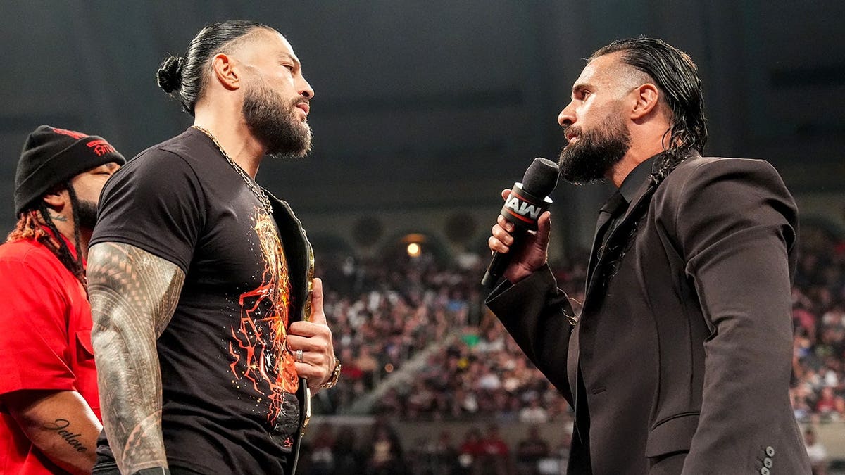 Roman Reigns and Seth Rollins speak in the ring during Monday Night RAW at Boardwalk Hall Arena.