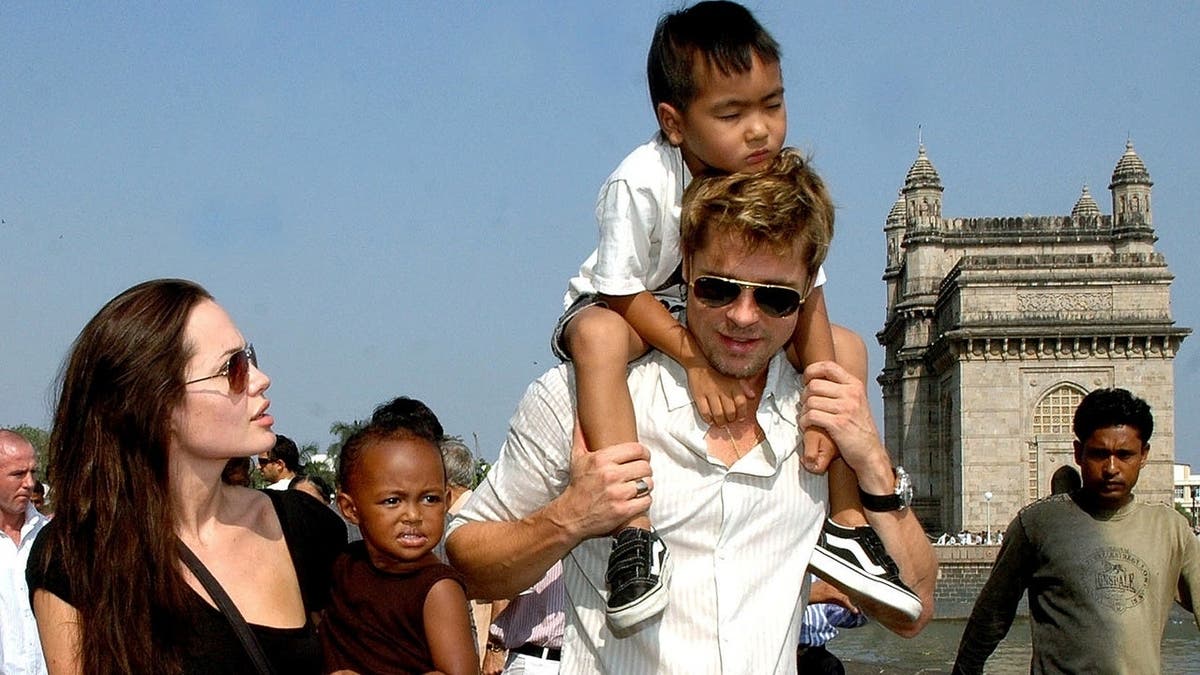 Angelina Jolie holds Zahara as Brad Pitt carries Maddox on a seafront promenade in Mumbai.
