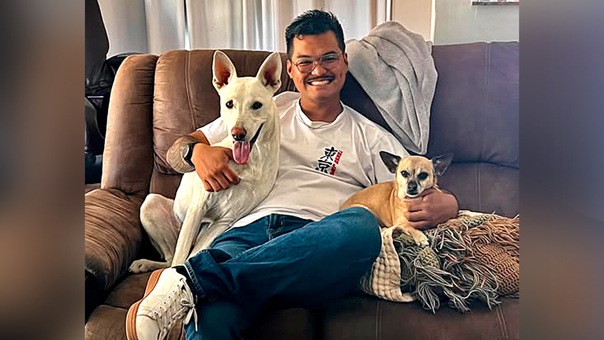 Un hombre sentado con dos perros