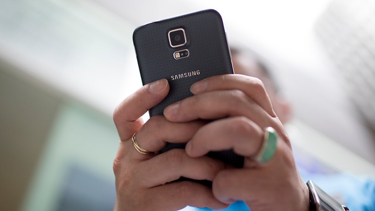 Person looking astatine their Android phone.