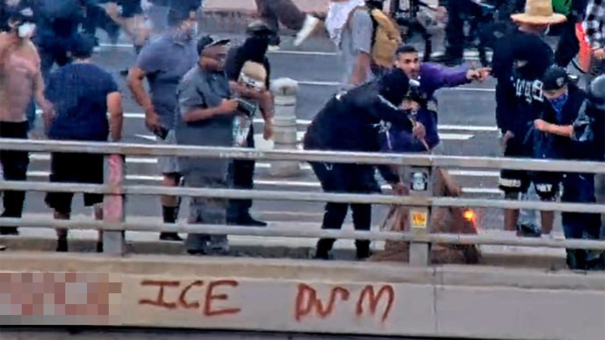 People on the Main Street overpass in Los Angeles appear to ignite debris during anti-ICE riots on June 8, 2025