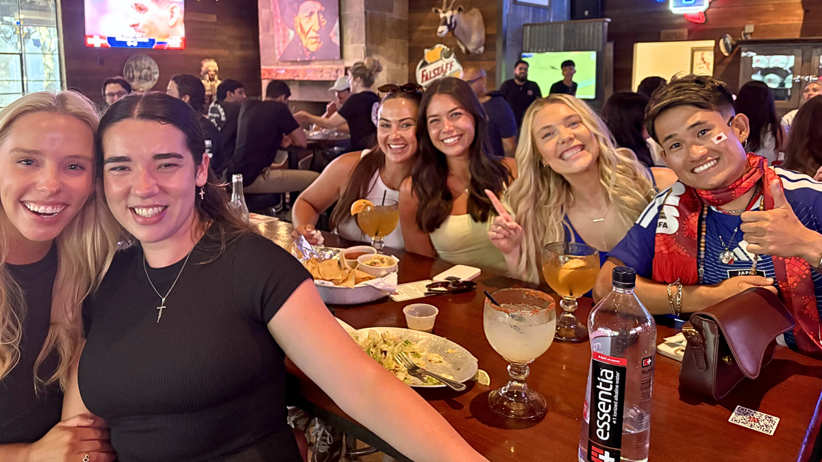 Un aficionado al fútbol japonés, el de la derecha, se hace un selfi con unas chicas en un bar de Dallas un partido del Mundial.
