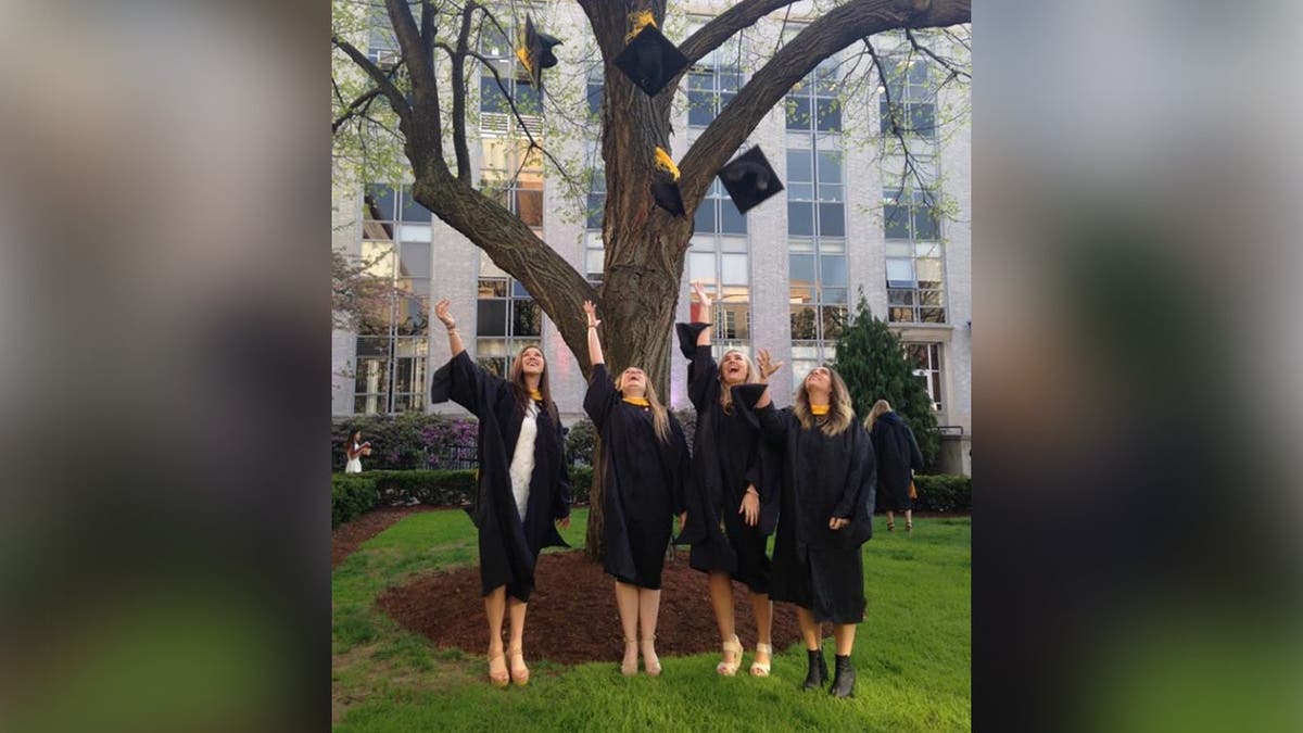 image shows four women throwing their hats