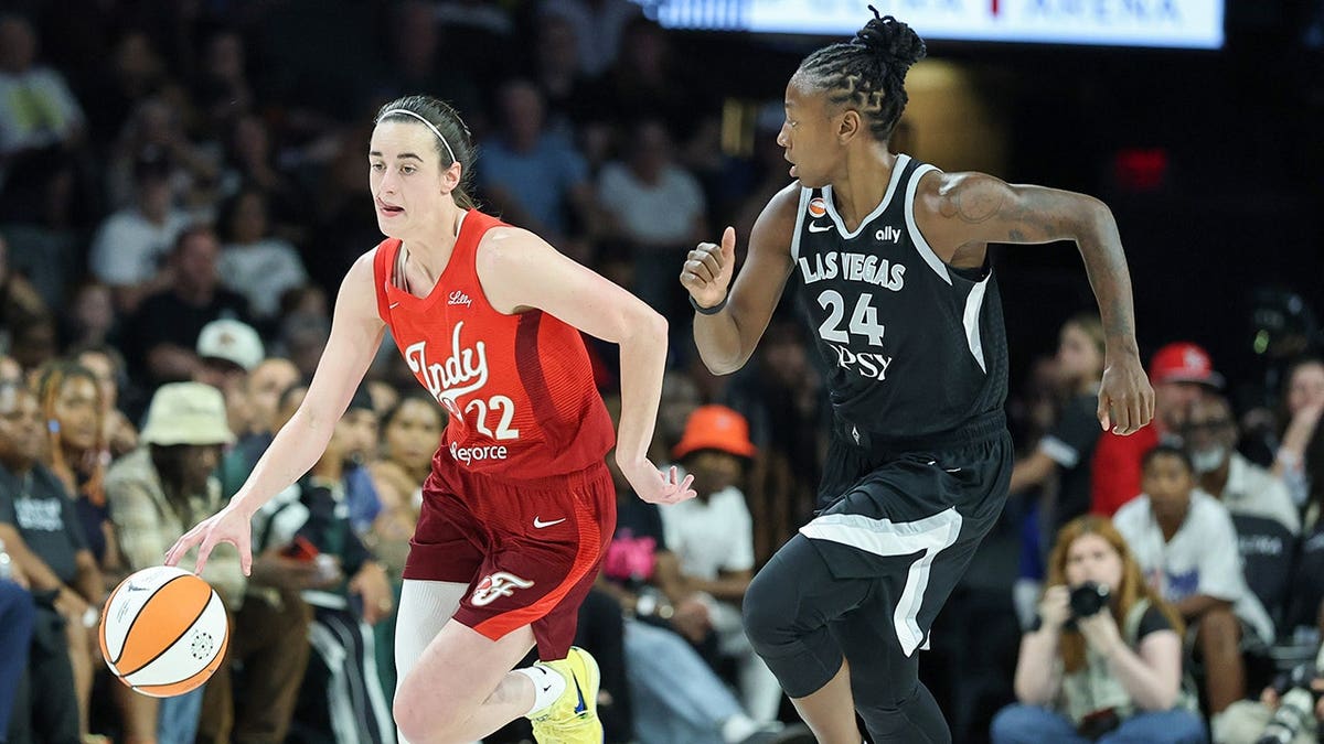 Caitlin Clark brings the ball up the court against Jewell Loyd during an NBA game.