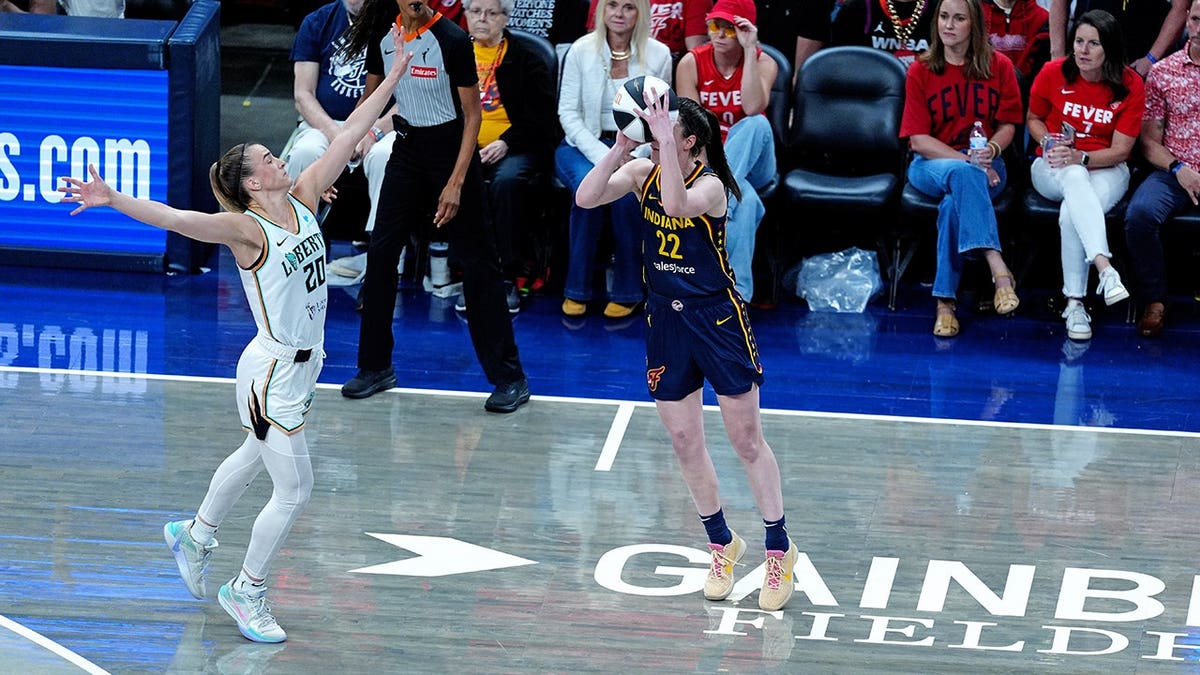 Caitlin Clark shoots a 3-point changeable against Sabrina Ionescu astatine Gainbridge Fieldhouse.