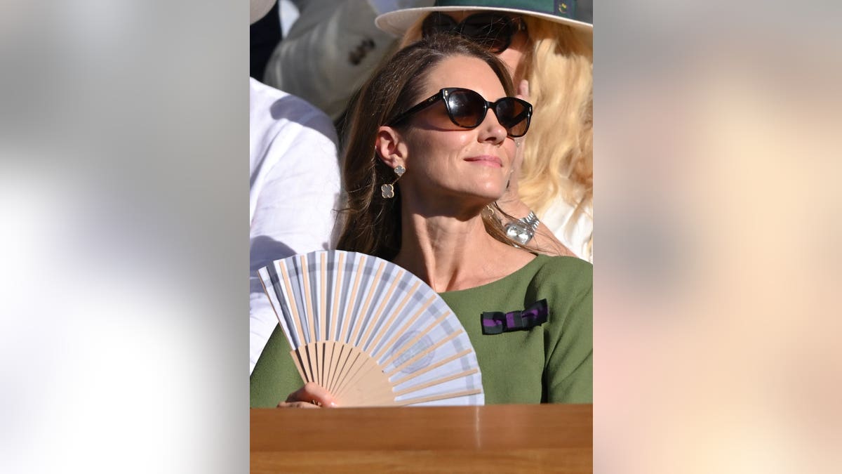 Catherine, Princess of Wales cools down with a fan at Wimbledon.