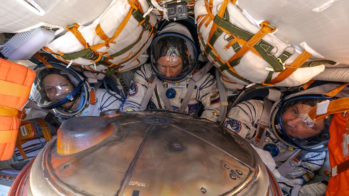 NASA astronaut Chris Williams, left, Roscosmos cosmonaut Sergey Kud-Sverchkov, center, and Roscosmos cosmonaut Sergei Mikaev are seen inside the Soyuz MS-28 spacecraft.
