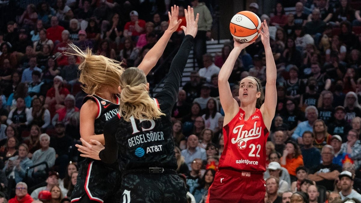Indiana Fever All-Star Caitlin Clark shoots over Portland Fire SG Sarah Ashlee Barker and C Luisa Geiselsoder at Moda Center in Oregon.