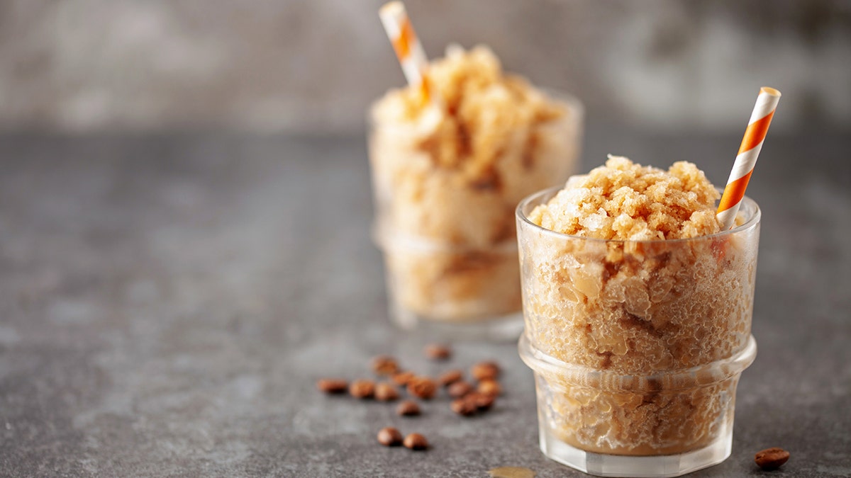 Frozen mocha coffee slushy in a glass on the table. Summer drink concept. Copy space