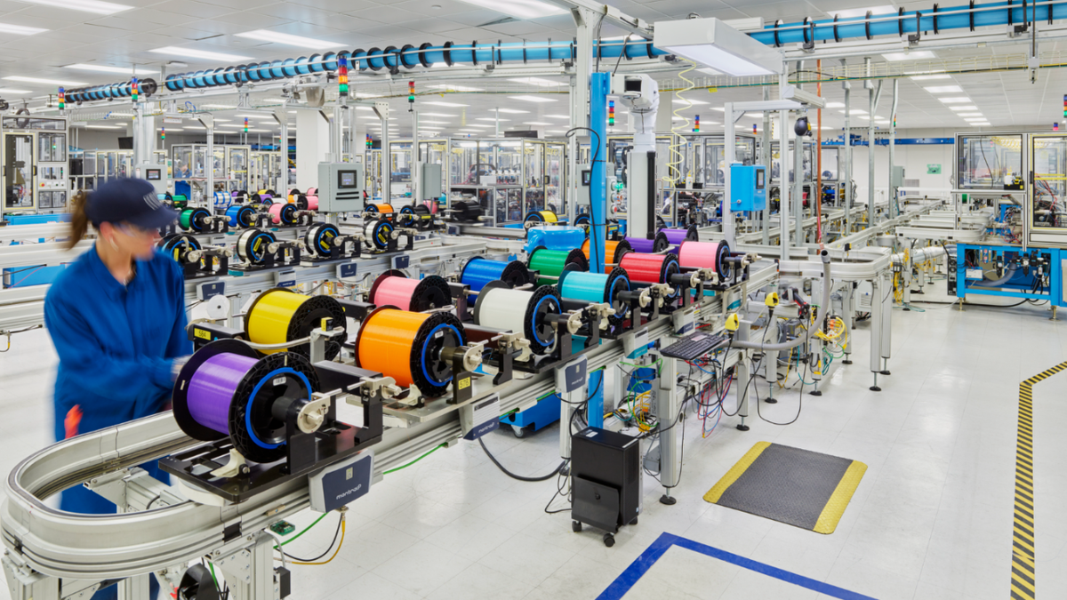 Um funcionário da Corning lida com fibra óptica como parte do processo de fabricação que dá suporte à infraestrutura de banda larga e telecomunicações.