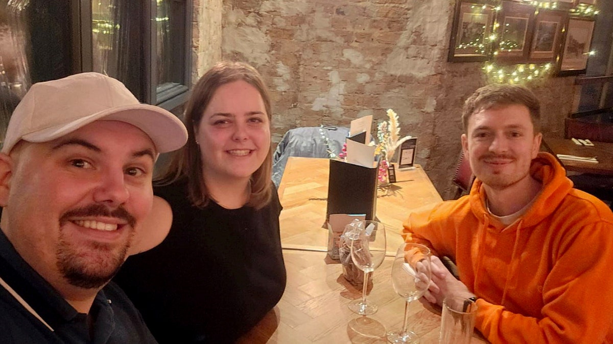 Dean Perryman of the U.K. sitting at the bar with two strangers.