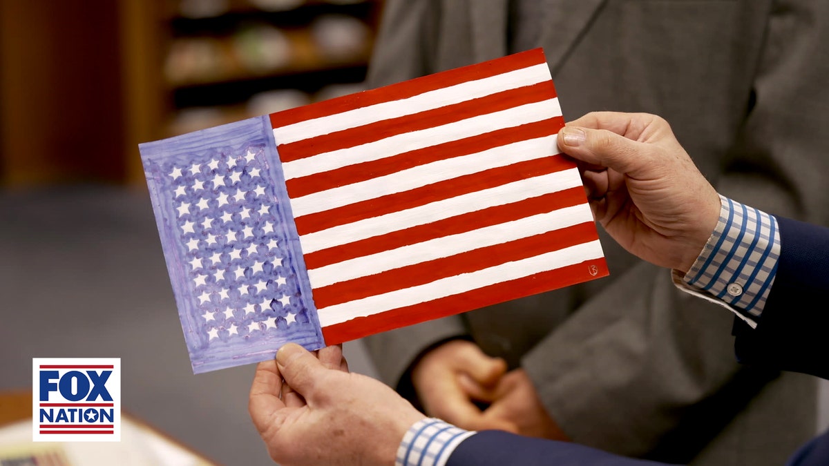 Hands clasp a hand-drawn projected 50-star American emblem plan submitted during the 1958 nationalist hunt for a caller U.S. emblem earlier Hawaii became the 50th state.