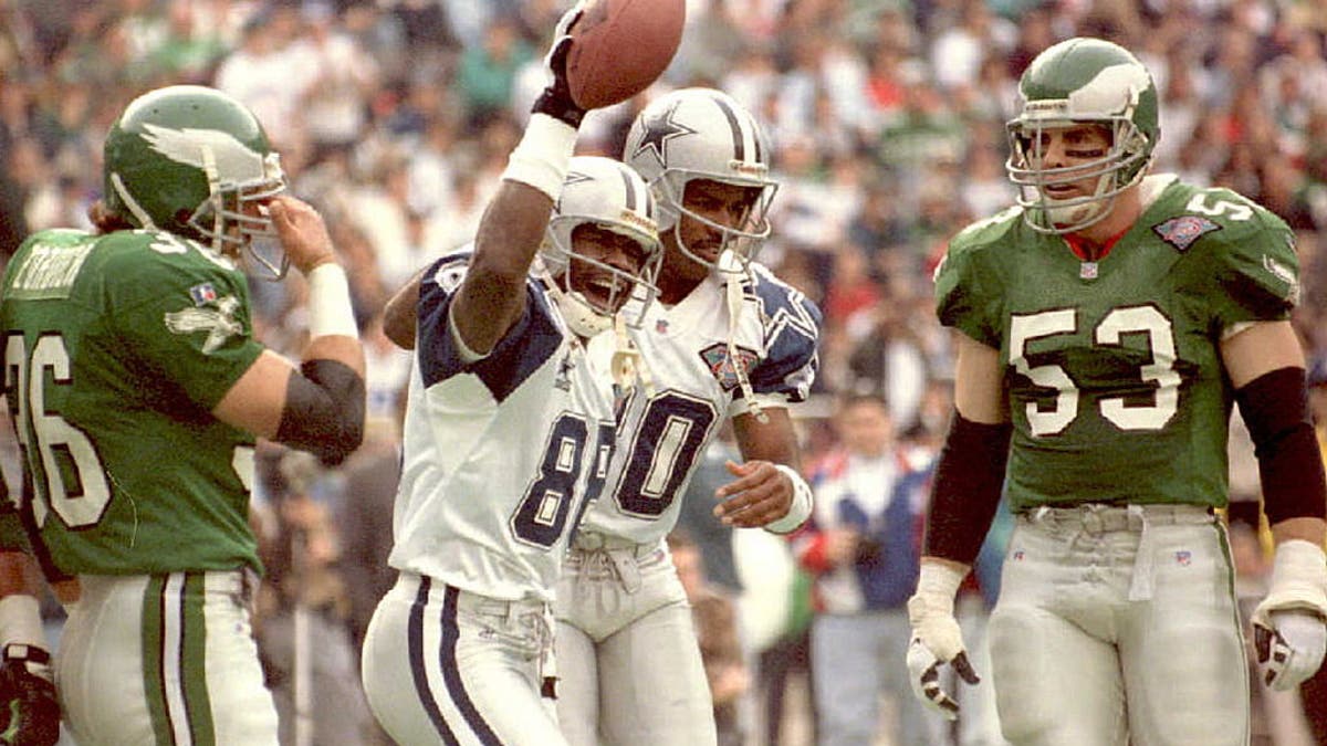 PHILADELPHIA, PA – DECEMBER 4: Philadelphia Eagles Bill Romanowski (R) and Michael Zordich watch the first quarter at Veterans Stadium on December 4. Dallas Cowboys wide receiver Michael Irvin (2nd L) celebrates his first touchdown of the game with teammate Alvin Harper. (COLOR KEY Eagles uniforms are green) (Photo credit should read TIMOTHY CLARY/AFP via Getty Images)