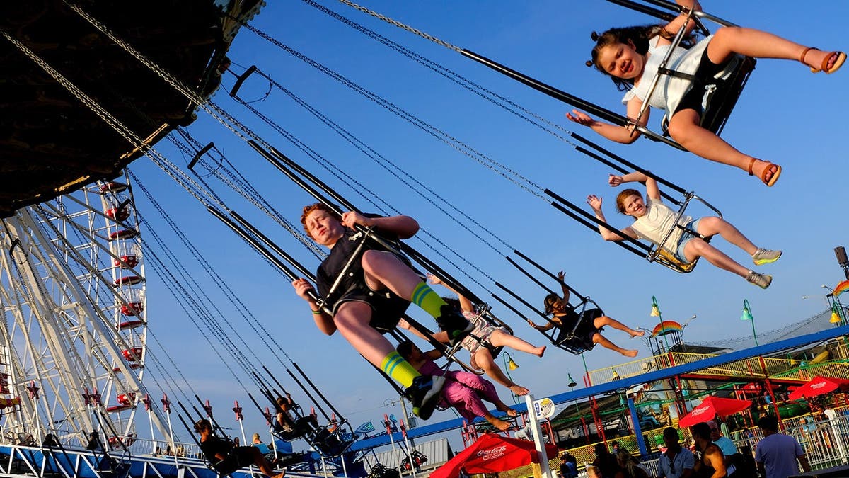 A family smiles while they enjoy an amusement park ride together.