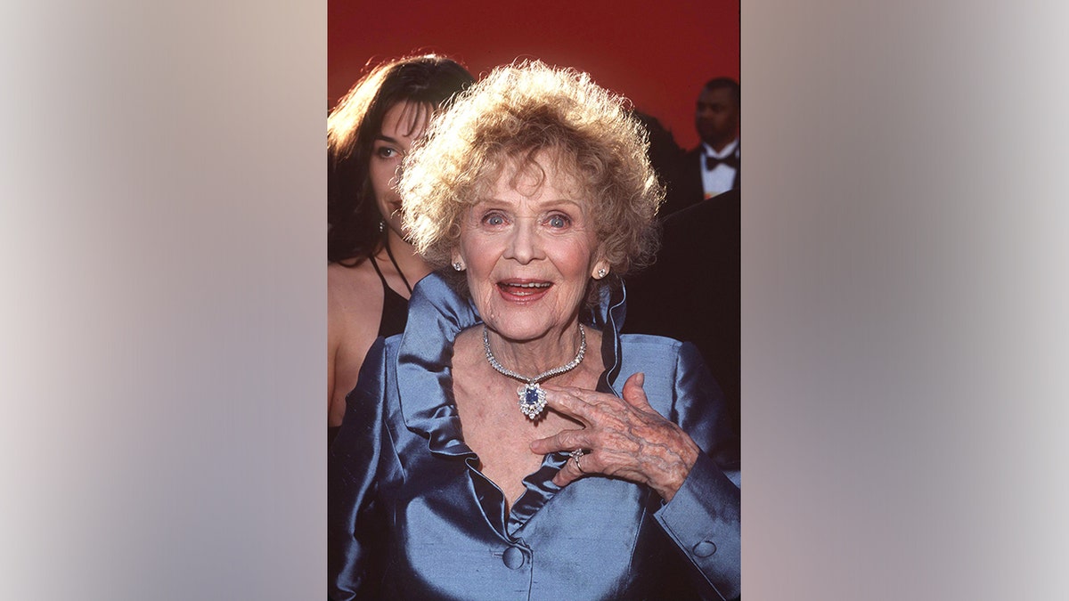 Gloria Stuart standing on a red carpet at the 70th Annual Academy Awards.