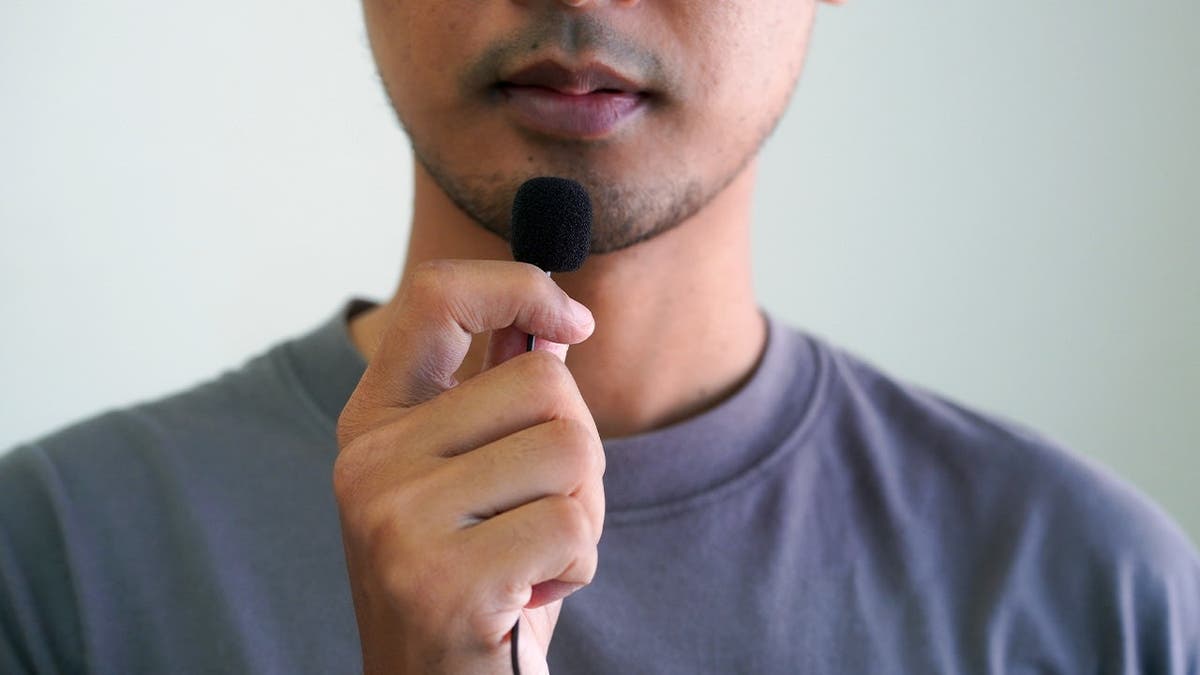 Guy holding tiny microphone