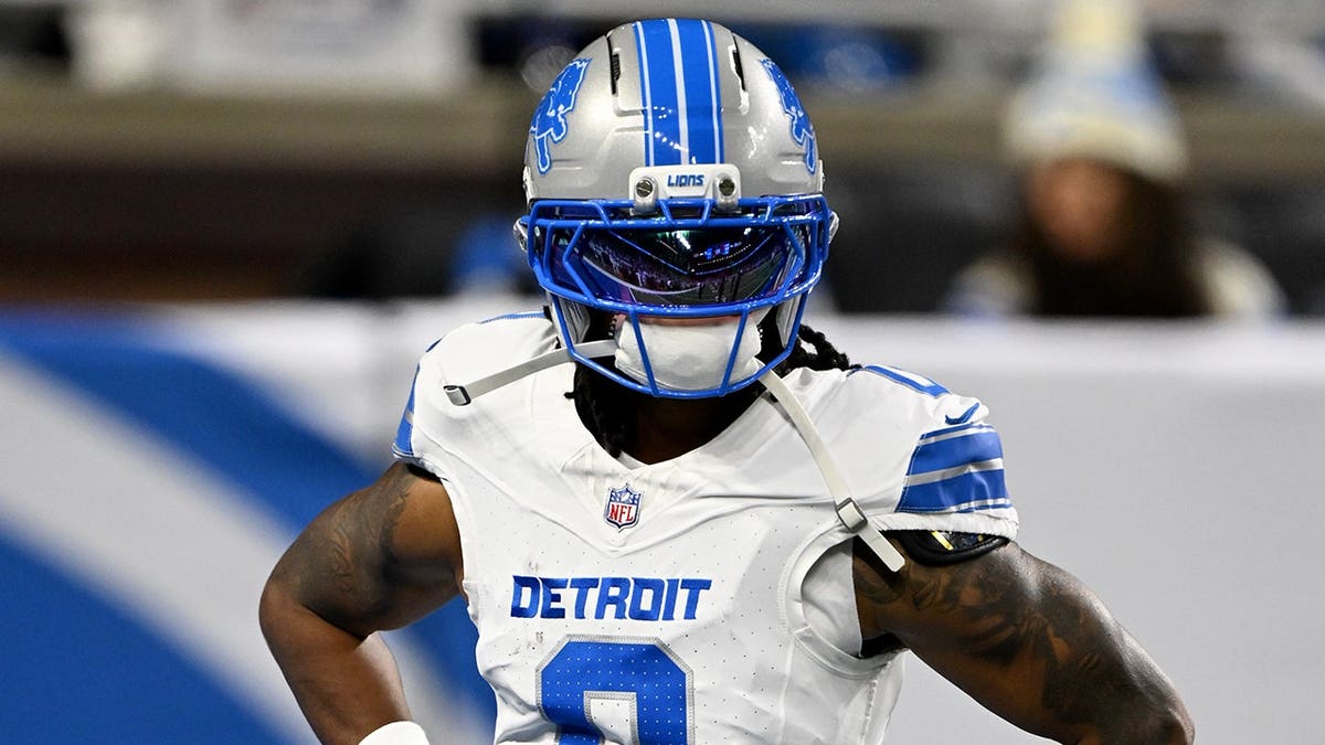Jahmyr Gibbs warms up before a game at Ford Field.