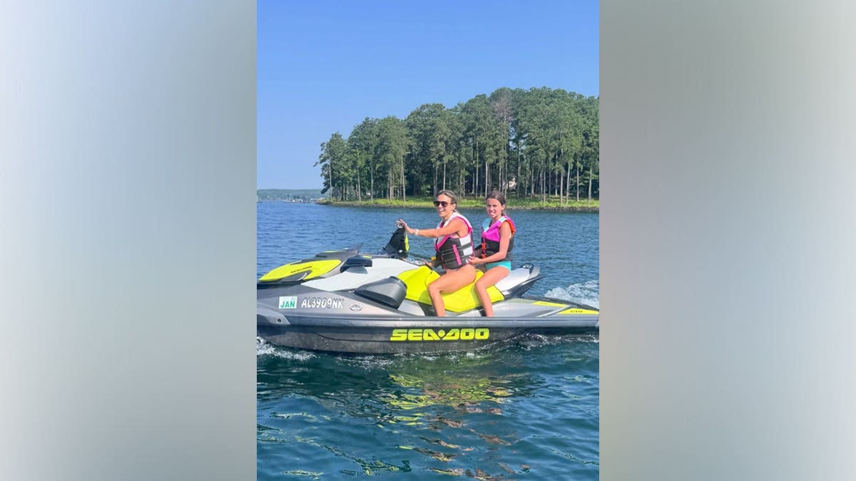 Jana Kramer smiles beside daughter Jolie while riding a bright yellow jet ski across the lake during Fourth of July weekend.