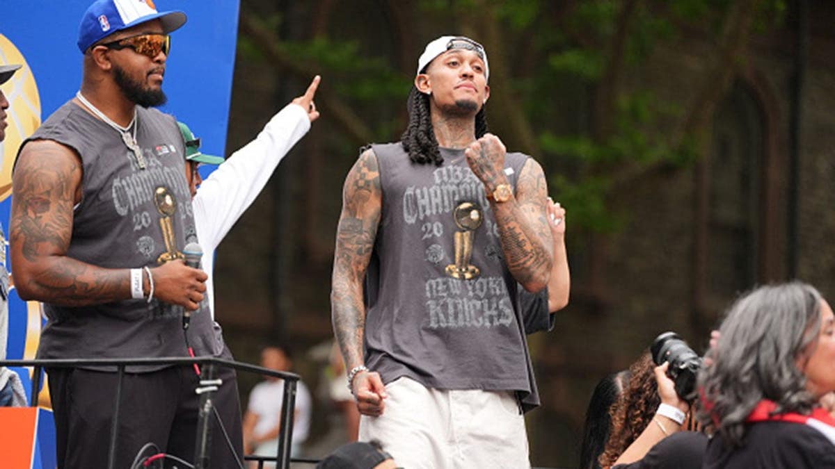Jordan Clarkson stands atop an open-top bus during a parade in New York City.