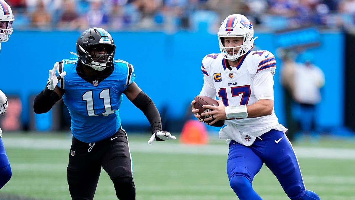 Josh Allen scrambles arsenic Nic Scourton pursues during an NFL game.