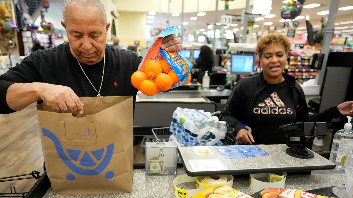 Algunas personas pagan sus compras en una tienda Kroger.