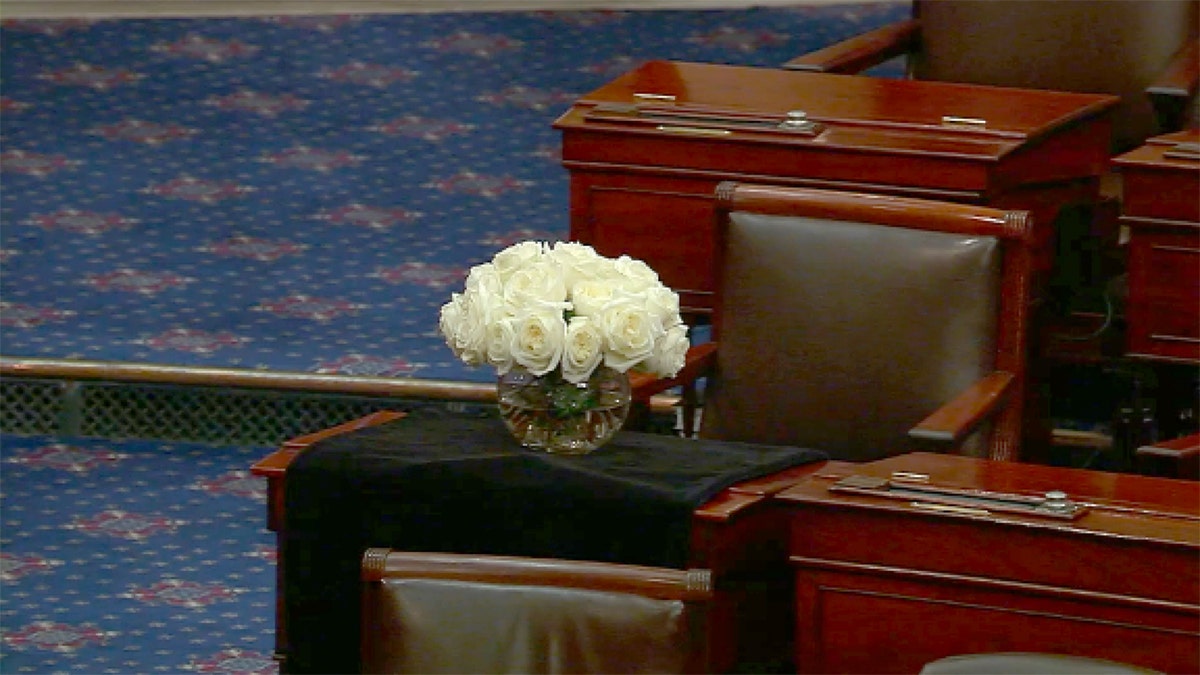 A bouquet of white roses left in a vase.