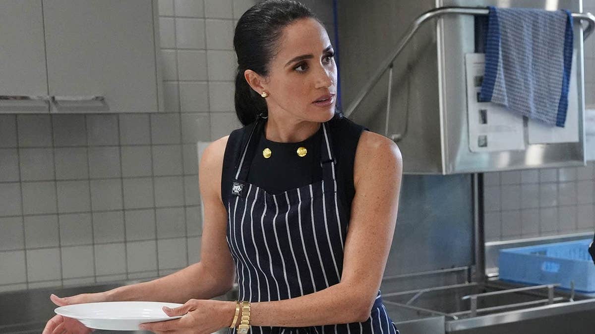 Meghan, Duchess of Sussex serves lunch with a staff member at a women's shelter in Melbourne.