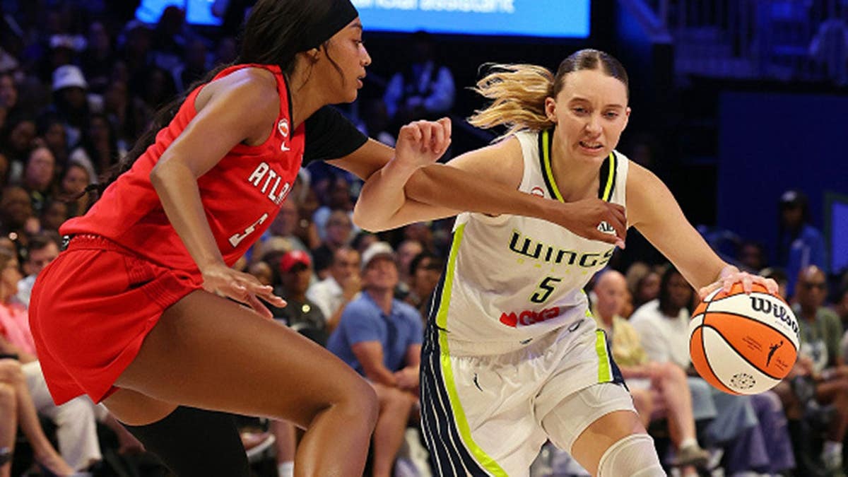 Paige Bueckers of the Dallas Wings drives past Angel Reese of the Atlanta Dream in a WNBA game.