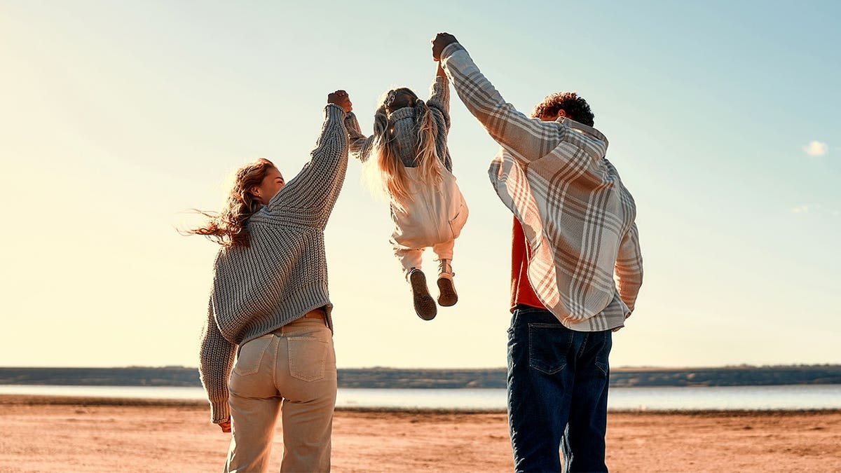Parents hold child's hands