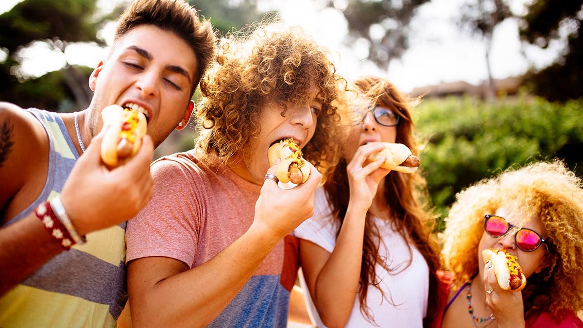 People enjoy eating hot dogs together.