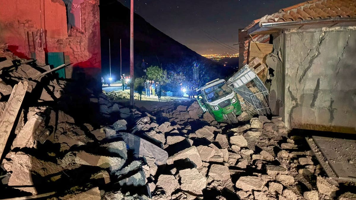 Motor tricycle sits amid debris after homes collapse in Pumpuya, Peru.