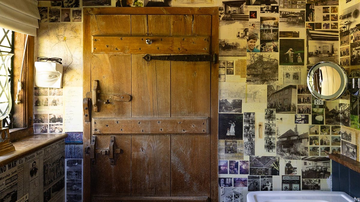 A bathroom with newspaper clippings chronicling the lives of the royal family plastered on the walls.