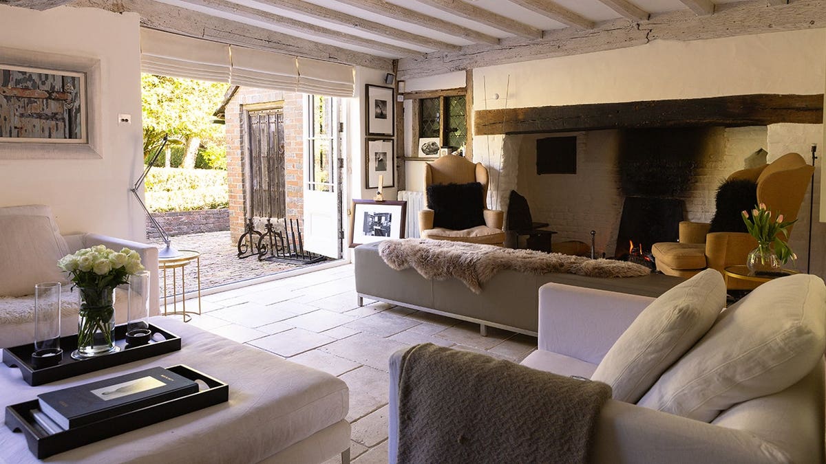 A rustic living room with multiple seating areas and a unique fireplace.