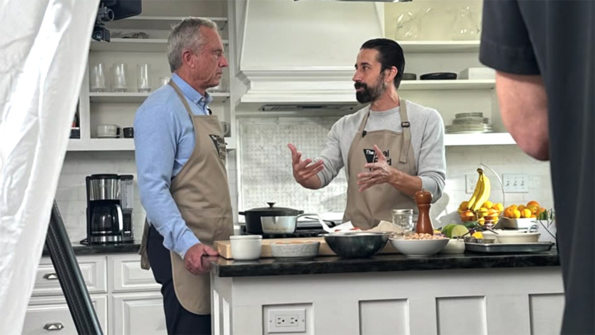 Robert F. Kennedy Jr. and Andrew Gruel are seen in a kitchen during a cooking demonstration recording session.