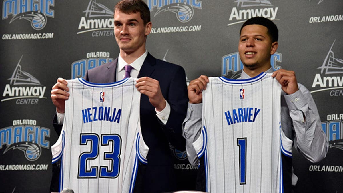 Rob Hennigan introduces Mario Hezonja and Tyler Harvey during a press conference.