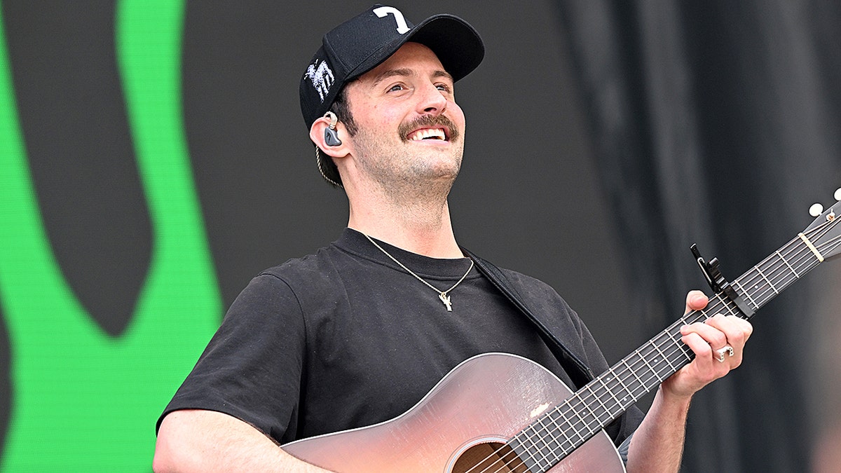 Ruston Kelly plays guitar onstage at music festival