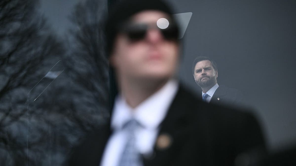 Secret Service supplier watches crowd arsenic Vice President JD Vance speaks down bulletproof glass.