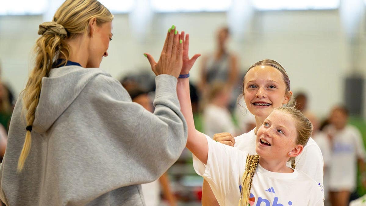 Sophie Cunningham interacts with young basketball players at a youth camp in Carmel, Indiana.