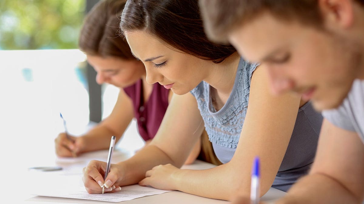 Students write on paper