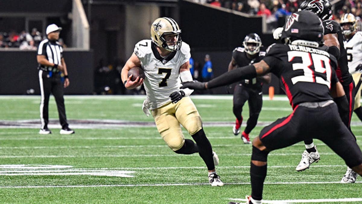 Taysom Hill runs with the ball during NFL game at Mercedes-Benz Stadium.